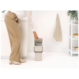 Femme ouvrant la poubelle Brabantia Sort & Go, 12 l, Soft Beige, dans la cuisine.