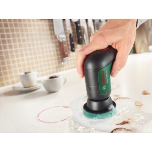 Tampone abrasivo da cucina Bosch in uso con spazzola a batteria Universal Brush per pulire le superfici.