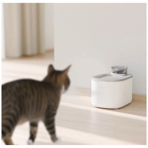 Fontana d'acqua intelligente Hombli bianca 3,5l con acqua corrente su pavimento chiaro, gatto osserva.