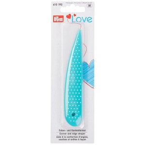 Modellatore per angoli e bordi Prym turchese in plastica con pois bianchi.