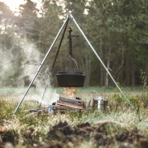 Petromax Dutch Oven FT6-T su treppiede sopra un fuoco aperto. Pentola in ghisa con coperchio e manico.