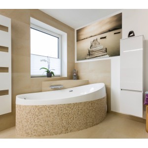 Bagno con piastrelle beige e mosaico, vasca da bagno, finestra e decorazioni.