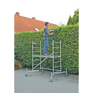 Impalcatura base Krause ClimTec con persona che taglia la siepe, altezza di lavoro 3 m.