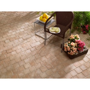 Pavés en béton Etrusco couleur sable (14x14x5 cm) sur terrasse avec mobilier de jardin.
