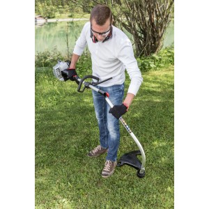 Débroussailleuse thermique Al-Ko BC 223 L-S en utilisation : homme coupant l'herbe avec la débroussailleuse dans le jardin.