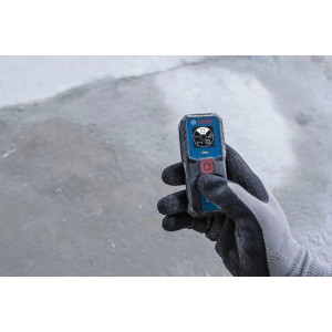 Hand hält Bosch Laser-Entfernungsmesser GLM50-21. Kompaktes Messwerkzeug mit Display und rotem Knopf für präzise Messungen.
