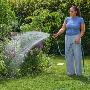 Donna che innaffia il giardino con il set di partenza Gardena Multifunzione Classic.
