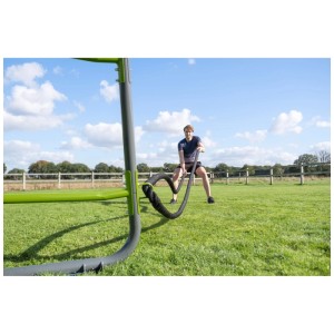 Exit Toys GetSet Monkeybar MB220 con persona che si allena con la corda da battaglia all'aperto.