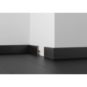Plinthe noire filmée (56 mm x 10 mm x 2400 mm) sur un mur.