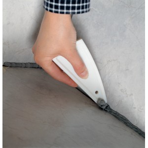 Lisseur de joints LUX en utilisation : main lissant un joint de silicone gris sur un carreau. Outil de maçonnerie pour des joints propres.