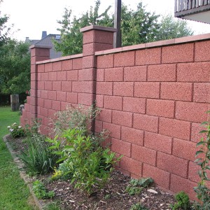 Mur de jardin en béton brun (Kann Normalstein) avec des plantes.