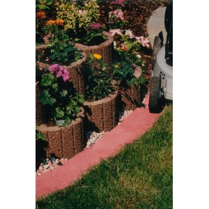 Bordure de gazon Maxi rouge en béton, délimitant une pelouse et un parterre de fleurs dans le jardin.
