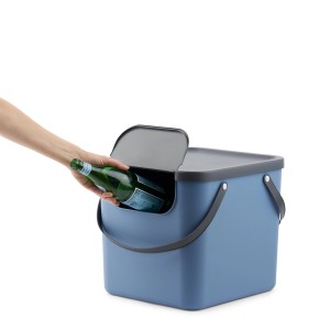 Rotho Albula Recycling-Mülleimer, 40 l, horizontblau. Hand wirft Glasflasche in den Abfallbehälter.