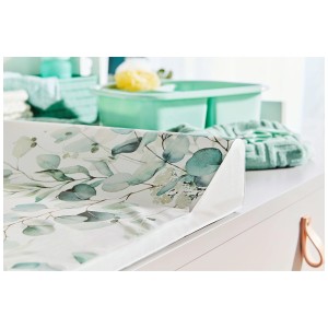 Matelas à langer cunéiforme Rotho Natural Leaves avec motif eucalyptus sur table à langer blanche.
