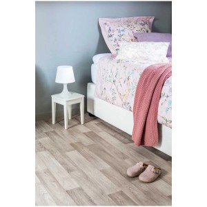 Revêtement de sol PVC gris aspect bois dans une chambre avec lit et table de chevet.