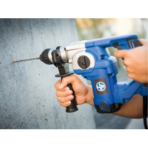 Trapano a percussione LUX Comfort SDS-Plus fora un foro nel muro di cemento.