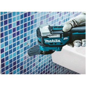 Outil multifonction sans fil Makita DTM52Z en utilisation sur un mur carrelé.