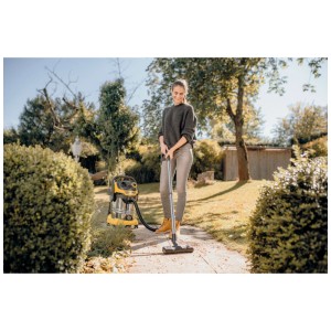 Femme aspirant des feuilles avec un aspirateur multifonction Kärcher. Sacs filtrants en non-tissé pour de longs intervalles d'aspiration.