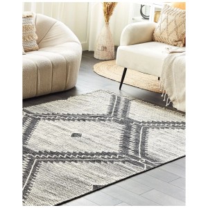 Tapis en coton noir Arbaa 140x200 cm avec motif géométrique bohème dans le salon.