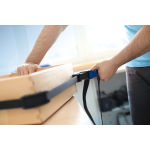 Sangle à cliquet LUX Comfort avec sangle de 4 m serrant un cadre en bois.