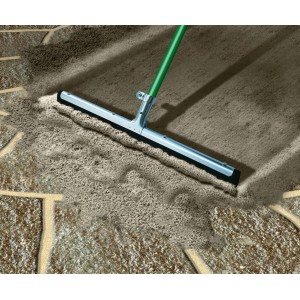 Applicazione di malta per fughe MEM grigio pietra su pavimentazione con un attrezzo.