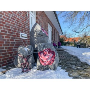 Graue Winterschutz-Vlieshauben mit Rosenmotiv schützen Pflanzen im verschneiten Garten vor Frost und Wind.